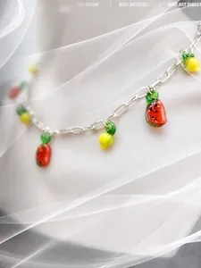 Vue artistique en flou artistique d'un collier de perles à pendentifs fruits sous un voile