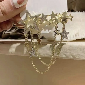 Close-up of golden star hair clip with rhinestone tassels and star-shaped charms
