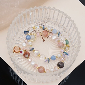 Detail of colorful beaded bracelet with freshwater pearls and amber crystal pendant