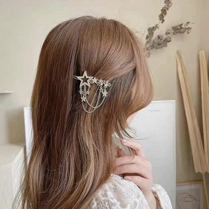 Star-shaped tassel hair clip with rhinestones and silver chains on brown hair