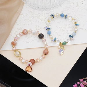 Detailed shot of handmade bracelets with rose quartz, aquamarine beads and freshwater pearls
