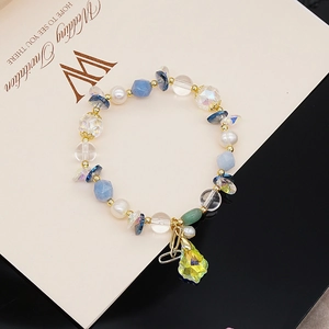 Close-up of handmade beaded bracelet with blue stone pearls and yellow crystal drop charm