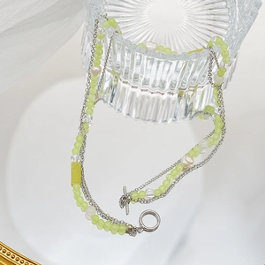Detail of multi-layer beaded necklace with green crystals, pearls and silver OT clasp