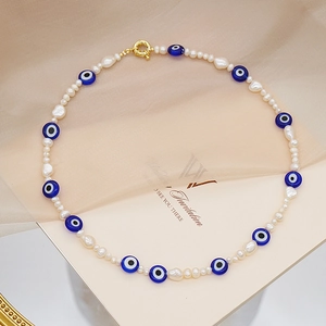 Collar de perlas barrocas con cuentas de ojo azul y cierre de langosta dorado