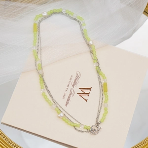 Detail of multi-layer necklace featuring green crystal beads and freshwater pearls
