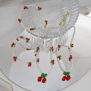 Détail du collier de cerises en perles sur verre et mesh avec effet miroir réfléchi