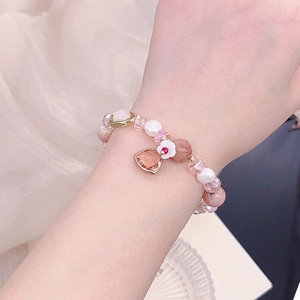 Detailed close-up of crystal bead bracelet with freshwater pearls and flower charm
