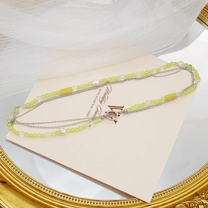 Detail of double-layer necklace with green beads, pearls and silver OT buckle closure