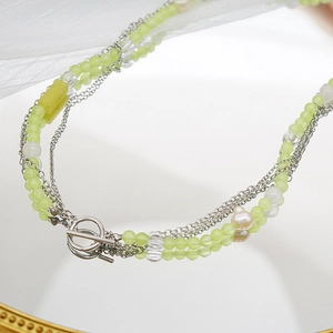 Detailed close-up of multi-layer beaded necklace with baroque pearl and silver OT clasp