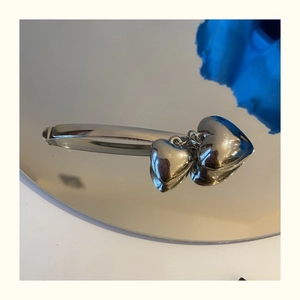 Primer plano de la pinza de pelo plateada con borlas de corazón y efecto metalizado