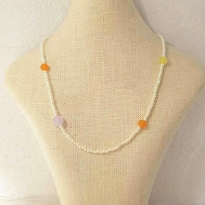 Collar de cuentas de ágata coloridas con perlas en un modelo para un look retro de verano