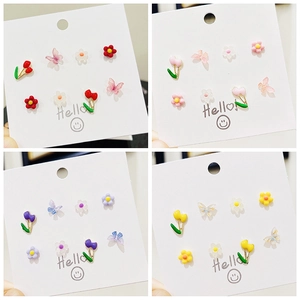 Dettaglio del set di orecchini in argento 925 con motivi a farfalla e tulipano