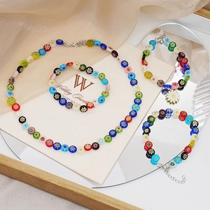 Dettaglio del set di gioielli in perle di vetro millefiori con ciondolo a margherita