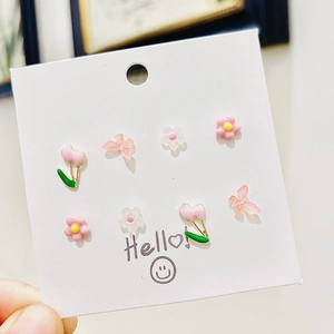 Set di orecchini a perno con farfalle e tulipani in argento 925 su carta bianca