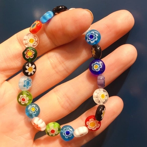 Dettaglio macro di perline colorate in vetro millefiori su bracciale elastico
