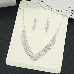 Close-up of sparkling silver rhinestone necklace and long fringe earrings on a display card
