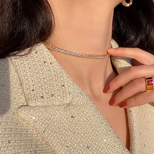 Détail du collier tennis 5mm en zircone et bague rubis dorée sur le mannequin