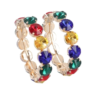 Macro detail of gold hoop earrings with multi-colored crystals for evening parties