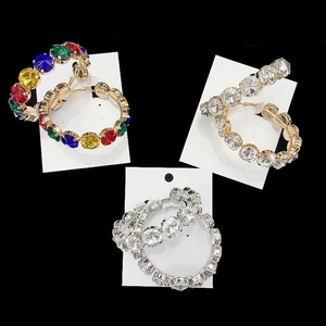 Detailed close-up of three pairs of rhinestone hoop earrings in gold, silver, and multicolor