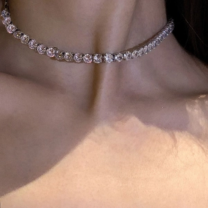 Gros plan d'un collier tennis en argent avec zircons ronds de 5 mm sur le cou