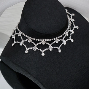 Vue macro détaillée du collier en maille strassée argentée à deux couches et pendentifs