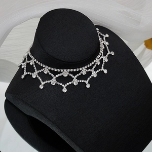 Détail du ras de cou en maille argentée orné de strass brillants multicouches