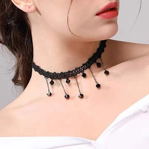 Détail d'un collier ras de cou élégant en dentelle noire avec perles facettées pendantes