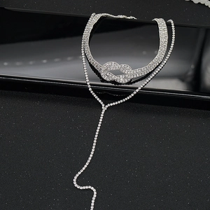 Détail d'un choker à nœud en strass argentés et collier en Y à pampilles pour tenue de soirée