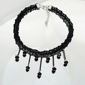 Détail d'un choker noir gothique avec pompons en cristal et chaîne argentée ajustable