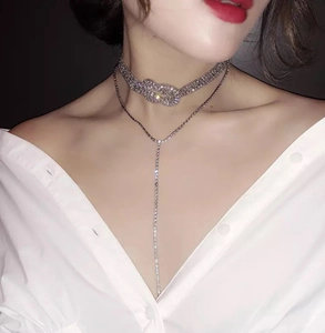 Détail d'un collier ras du cou en strass à double épaisseur avec nœud et pampille en Y