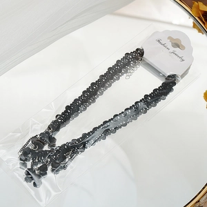 Gros plan d'un collier choker en dentelle noire avec pendentifs en perles à facettes