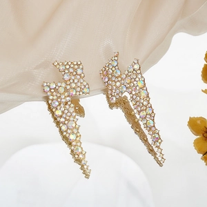 Macro detail of long lightning crystal earrings with colorful rhinestones on gold base