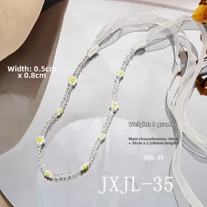 Macro detail of pearl crystal choker with floral beads and transparent ribbons