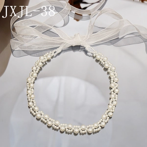 Detail of woven pearl choker necklace with white chiffon ribbons on reflective surface