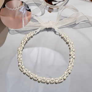 Detail view of pearl choker with white organza ribbon ties and woven wave patterns