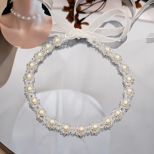 Detailed macro view of pearl and crystal choker with white organza ribbon ties