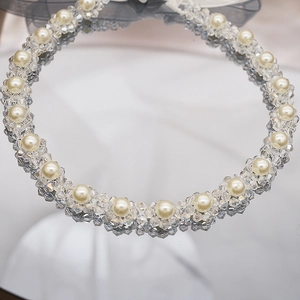 Close-up of pearl and crystal headband with a delicate blue tulle bow detail