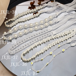 Elegant pearl and crystal ribbon headband necklaces displayed on a mirror surface
