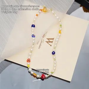 Détail du collier de perles à fleurs avec des perles en verre et des breloques