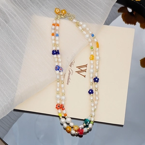 Détail d'un collier de perles double couche avec fleurs en verre colorées et perles de champignon