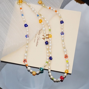 Détail du collier en perles d'eau douce avec perles fleurs et pendentif champignon rouge