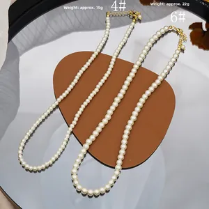 Comparison detail of size 4 and size 6 pearl necklaces with golden lobster clasps