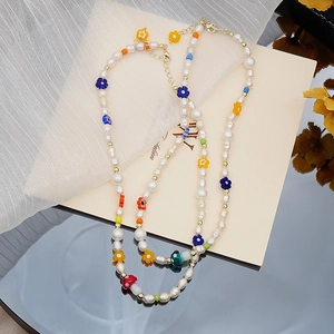 Collier en perles fait main avec fleurs en verre colorées et breloques champignon sur voile