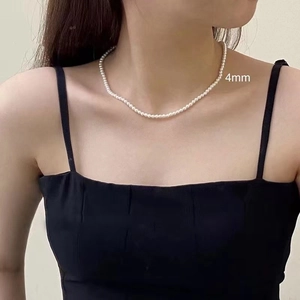 Close-up of elegant 4mm white glass pearl necklace worn on model for french style