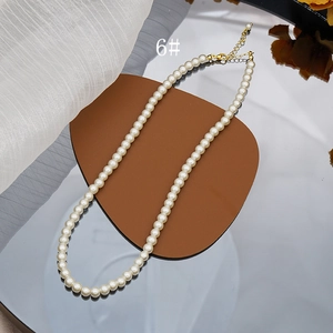 Close-up of creamy white pearl necklace with adjustable gold lobster clasp and chain