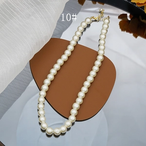 Detail shot of 8mm cream glass pearls with golden lobster clasp and extension chain