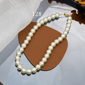Detail of elegant cream glass pearl necklace with gold clasp on a mirror tray