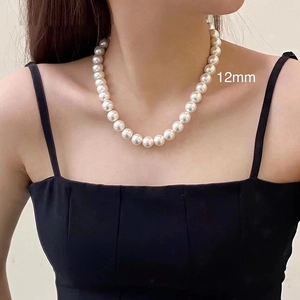 Detail of 12mm white glass pearl necklace showing uniform luster on a model neck