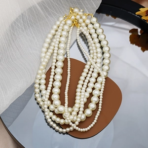 Detailed view of various sizes of elegant white glass pearl necklaces with gold clasps