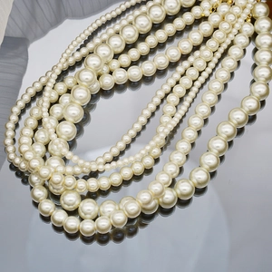 Detail of cream glass pearl necklaces in various sizes with golden lobster clasps